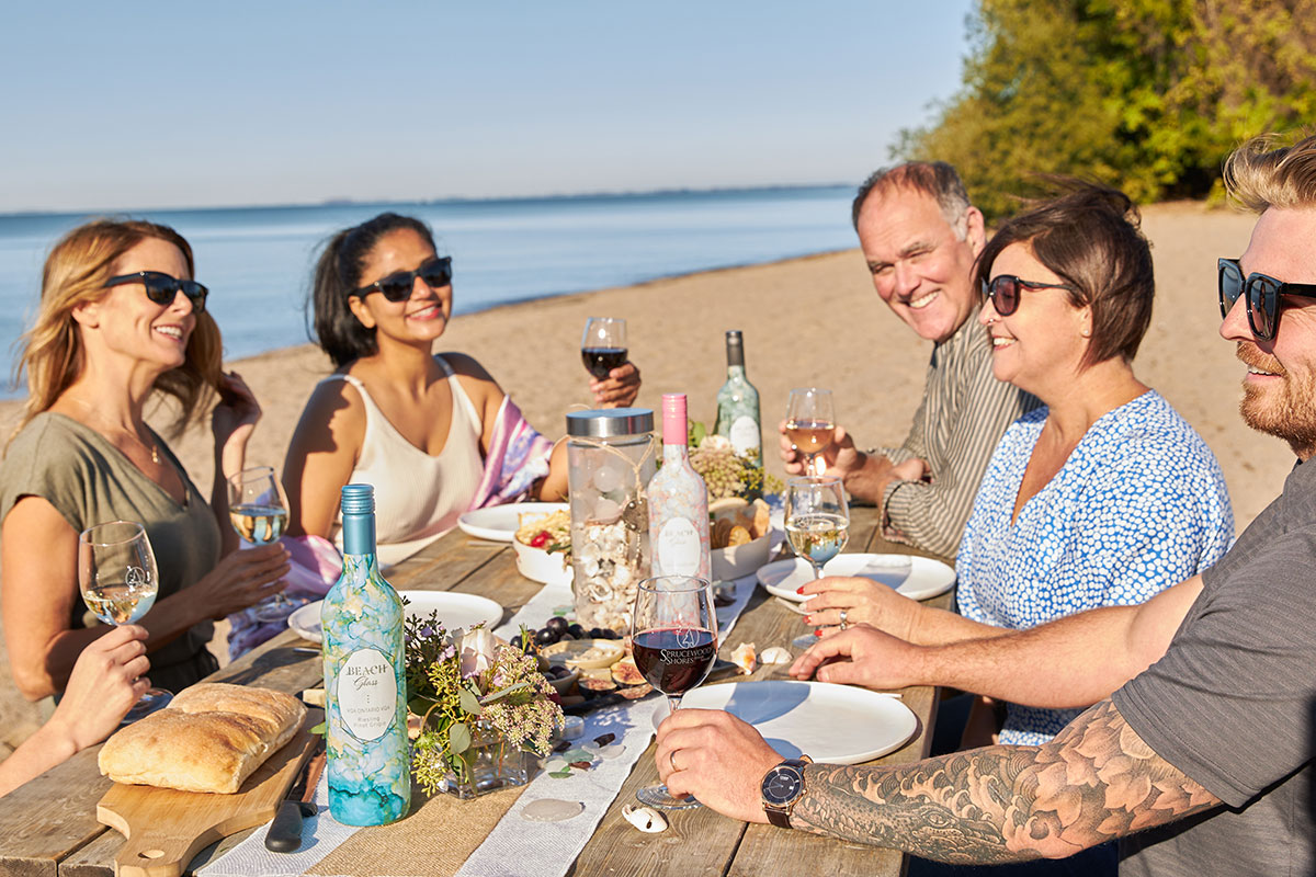 3 couples enjoying wine on beach